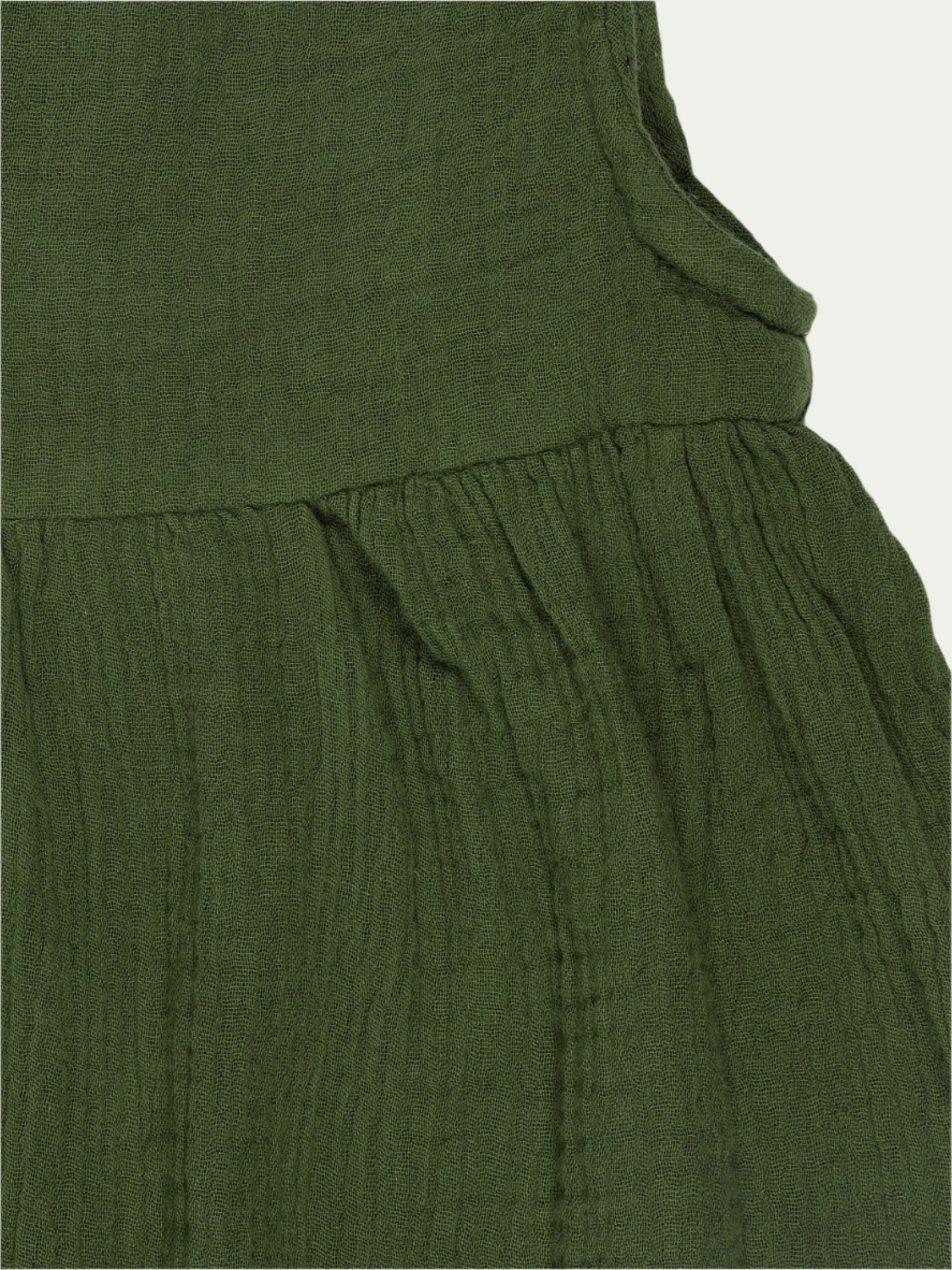 Close-up of pleated design and fabric texture on forest green organic cotton sleeveless baby dress – breathable and eco-friendly by Ray&Baby.