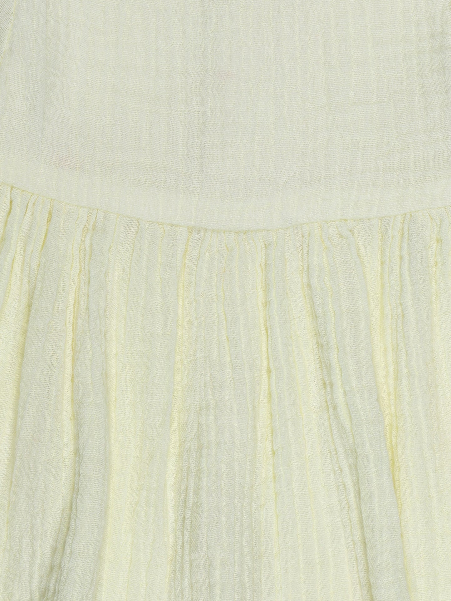 Close-up of pleated design and fabric texture on yellow organic cotton baby dress – breathable and eco-friendly by Ray&Baby.