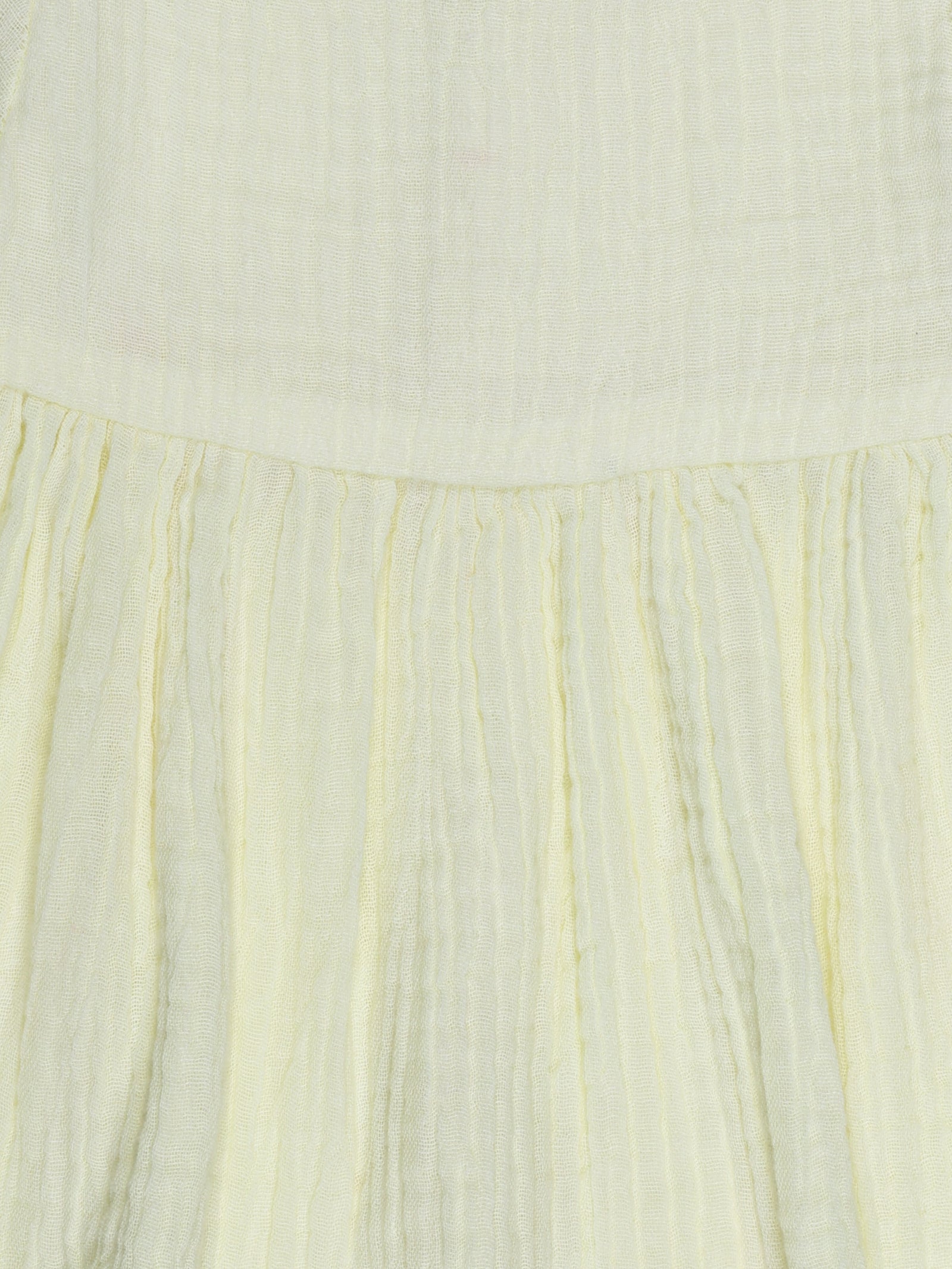 Close-up of pleated design and fabric texture on yellow organic cotton baby dress – breathable and eco-friendly by Ray&Baby.