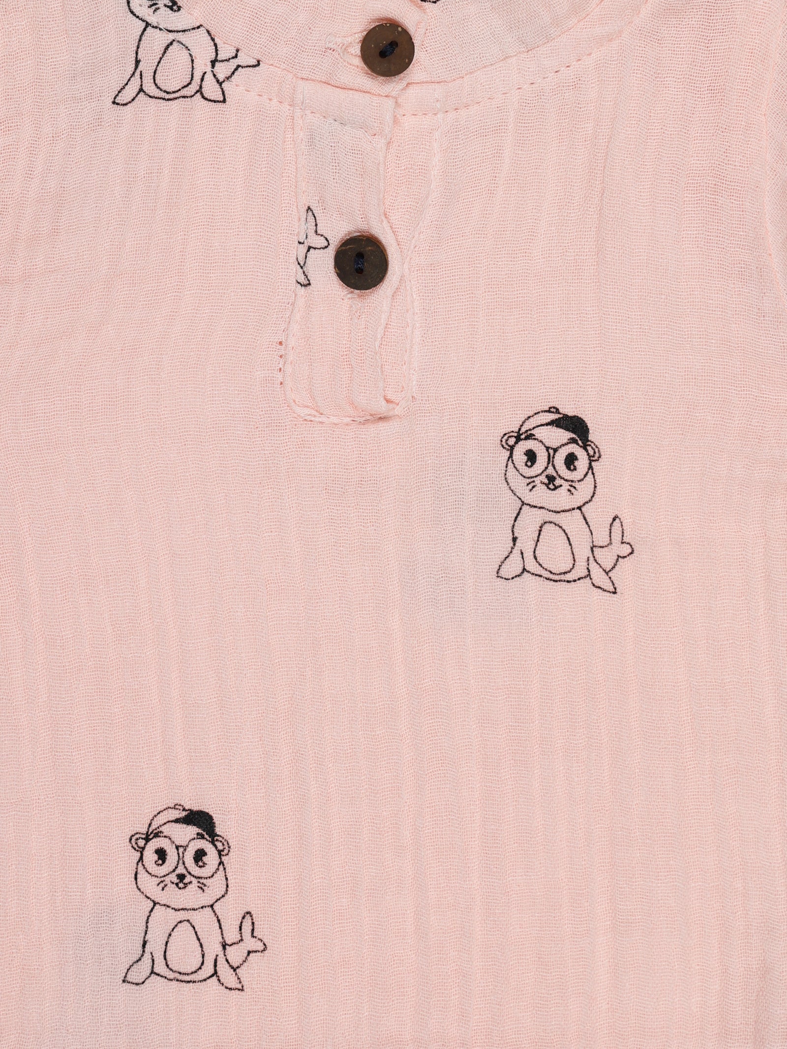 Close-up of wooden buttons and seal print on pink organic cotton baby shirt – breathable and eco-friendly fabric by Ray&Baby.